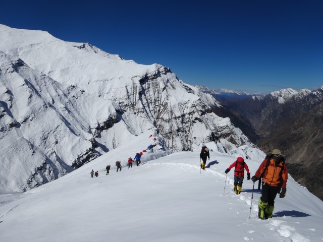 The team stretching their legs after two sedentary days snowed in. Our Pangi ridge camp is in the background.