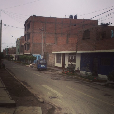 Peruvian street with tuk tuk.