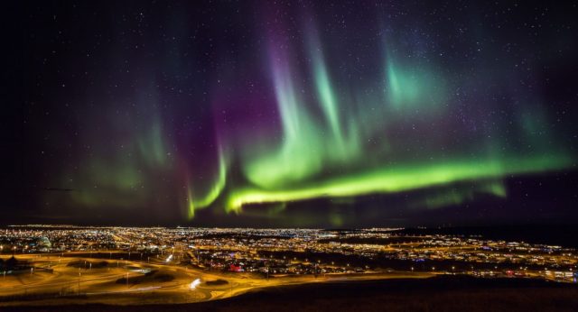 Northern lights dancing over the city of Reykjavik, Iceland.  Credit: The Aurora Zone & Visit Iceland